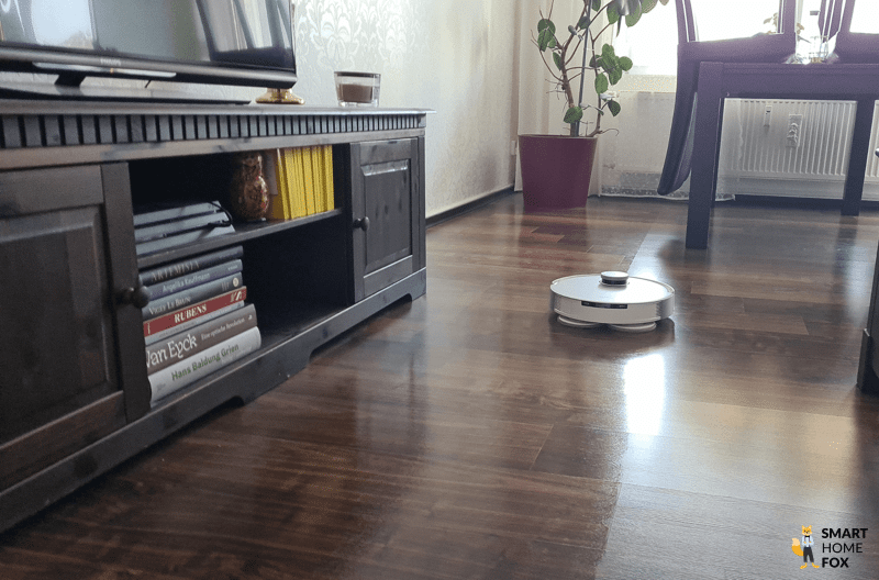 Der ECOVACS DEEBOT X1 OMNI wischt im Test den Laminatboden im Wohnzimmer.
